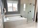 Luxurious bathroom featuring a soaking tub, separate glass-enclosed shower, and stylish fixtures at 933 Hunter Shores Ave, North Las Vegas, NV 89084
