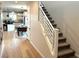 Bright hallway with hardwood floors leads to a dining area and staircase with modern white railing at 933 Hunter Shores Ave, North Las Vegas, NV 89084