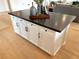 Spacious kitchen island with a dark countertop, white cabinets, and hardwood floors at 933 Hunter Shores Ave, North Las Vegas, NV 89084