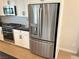Bright kitchen featuring a stainless steel refrigerator, white cabinets, and black countertops at 933 Hunter Shores Ave, North Las Vegas, NV 89084