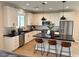 Stylish kitchen with stainless steel appliances, white cabinetry, black countertops, and a kitchen island at 933 Hunter Shores Ave, North Las Vegas, NV 89084