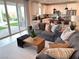 Open-concept living space with a sliding glass door, plush sofas, and hardwood floors at 933 Hunter Shores Ave, North Las Vegas, NV 89084