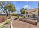 Well manicured backyard with rock ground cover, garden beds and an outdoor patio at 9562 Collinsleap Ct, Las Vegas, NV 89123