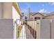 A peek through the iron gate offers a glimpse of the landscaped backyard and walkway at 9562 Collinsleap Ct, Las Vegas, NV 89123