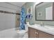 Well lit bathroom featuring tiled shower-tub combo with modern vanity and fixtures at 9562 Collinsleap Ct, Las Vegas, NV 89123