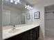 Bright bathroom featuring a vanity with dark wood cabinets and a white countertop, plus a large mirror at 9604 Vital Crest St, Las Vegas, NV 89123