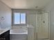 Bathroom featuring a separate tub and shower, dual sinks, and dark cabinets at 9604 Vital Crest St, Las Vegas, NV 89123