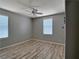 Bedroom featuring neutral walls, wood-look flooring, a ceiling fan, and two windows at 9604 Vital Crest St, Las Vegas, NV 89123
