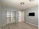 Bedroom featuring neutral walls, wood-look flooring, a walk-in closet, and a mounted television at 9604 Vital Crest St, Las Vegas, NV 89123