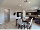 Open-concept kitchen and dining area with dark cabinets, stainless steel appliances, and modern lighting at 9604 Vital Crest St, Las Vegas, NV 89123