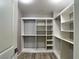 Spacious walk-in closet with custom built-in shelving and ample storage space, as well as wood-look floors at 9604 Vital Crest St, Las Vegas, NV 89123