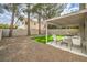 Backyard featuring an artificial lawn, a gravel area, and a covered patio with seating at 10009 Coral Sands Dr, Las Vegas, NV 89117