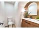 Charming half bathroom boasting modern fixtures, wooden vanity, and a gold accent wall at 10009 Coral Sands Dr, Las Vegas, NV 89117