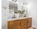 Modern bathroom featuring a double vanity with wood cabinetry and dual mirrors at 10009 Coral Sands Dr, Las Vegas, NV 89117