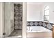 Contemporary bathroom with a glass shower, soaking tub, and geometric tile accents at 10009 Coral Sands Dr, Las Vegas, NV 89117