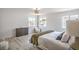 Bright bedroom with multiple windows, wood floors, and a cozy seating area at 10009 Coral Sands Dr, Las Vegas, NV 89117