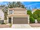Two-story home showcasing a tile roof, neutral stucco exterior, and attached two-car garage at 10009 Coral Sands Dr, Las Vegas, NV 89117