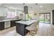 Modern kitchen with island gas cooktop, stainless steel appliances, and light wood flooring at 10009 Coral Sands Dr, Las Vegas, NV 89117