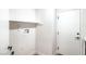 Laundry room featuring tile floors, neutral walls, a shelf, and a door to the outside at 10009 Coral Sands Dr, Las Vegas, NV 89117