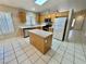 Spacious kitchen with stainless steel appliances, tile floor and an island workstation at 10025 Catseye Cove Ct, Las Vegas, NV 89183