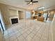 Bright open-concept kitchen and living room area with fireplace and tile flooring at 10025 Catseye Cove Ct, Las Vegas, NV 89183