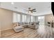 Bright living room featuring a large sectional sofa, wood flooring, and sliding glass doors at 1014 Solemn Cactus Ave, North Las Vegas, NV 89031