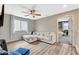 Bright living room with wood floors, large sectional, ceiling fan, and access to the main bedroom at 1014 Solemn Cactus Ave, North Las Vegas, NV 89031
