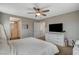 Comfortable main bedroom featuring carpet, a ceiling fan, a TV, and an ensuite bathroom at 1014 Solemn Cactus Ave, North Las Vegas, NV 89031