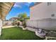 Backyard featuring a patio, desert landscaping, and artificial grass at 10166 Monks Hood Ct, Las Vegas, NV 89183