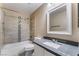Cozy bathroom featuring tiled shower over tub, toilet, and vanity with storage at 10166 Monks Hood Ct, Las Vegas, NV 89183
