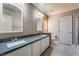 Stylish bathroom with double sinks, gray countertops, white cabinets, and a tiled floor at 10166 Monks Hood Ct, Las Vegas, NV 89183