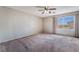 Bedroom showcasing a ceiling fan, window with view, and neutral carpet at 10166 Monks Hood Ct, Las Vegas, NV 89183