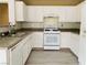 Well-lit kitchen with white cabinets, granite countertops, and stainless-steel appliances at 10238 Missouri Meadows St, Las Vegas, NV 89183