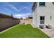 Backyard featuring an area of green lawn, patio and desert landscaping at 10273 Fragrant Apple Ct, Las Vegas, NV 89141