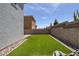Artificial turf grass and rock landscaping are displayed in this fenced in backyard at 10273 Fragrant Apple Ct, Las Vegas, NV 89141