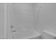 Bright and clean white tiled bathtub with shower head, tub faucet, and white fixtures at 10273 Fragrant Apple Ct, Las Vegas, NV 89141