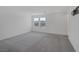 Spacious bedroom with gray carpeting, two windows, and white walls at 10273 Fragrant Apple Ct, Las Vegas, NV 89141