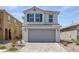 Charming two-story home featuring a gray two-car garage, brick driveway, and well-manicured landscaping at 10273 Fragrant Apple Ct, Las Vegas, NV 89141