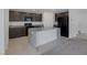 Modern kitchen featuring a spacious island, granite countertops, and sleek black appliances for a contemporary look at 10273 Fragrant Apple Ct, Las Vegas, NV 89141
