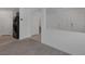 Bright living room featuring neutral carpeting, access to the staircase, and an open view to the kitchen at 10273 Fragrant Apple Ct, Las Vegas, NV 89141