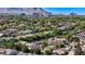 Panoramic aerial shot of a neighborhood surrounded by lush greenery and distant mountains on a sunny day at 10389 Walking View Ct, Las Vegas, NV 89135