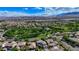 Aerial view showcasing a suburban neighborhood and a community park with mature trees, pathways and landscaping at 10389 Walking View Ct, Las Vegas, NV 89135