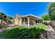 Backyard with a covered patio, greenery, block wall, and stone border at 10389 Walking View Ct, Las Vegas, NV 89135