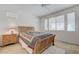 Comfortable bedroom with a wooden bed frame, a patterned quilt, a ceiling fan, and large windows at 10389 Walking View Ct, Las Vegas, NV 89135