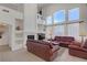 Bright living room with high ceilings, fireplace, and large windows allowing natural light at 1421 Via Savona Dr, Henderson, NV 89052