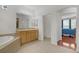 Main bathroom with tiled floors, soaking tub, and a view to the bedroom at 1421 Via Savona Dr, Henderson, NV 89052