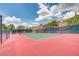 Community tennis court with green and red surface surrounded by mature trees at 1421 Via Savona Dr, Henderson, NV 89052
