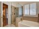 Bathroom featuring a soaking tub, glass enclosed shower and shuttered window at 1574 Livingston Dr, Henderson, NV 89012