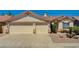 Charming single-story home showcasing a three-car garage and desert landscaping at 1574 Livingston Dr, Henderson, NV 89012