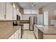 A spacious kitchen featuring white cabinets, granite countertops, stainless appliances and tile floors at 1574 Livingston Dr, Henderson, NV 89012
